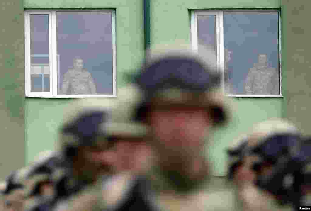 Georgian soldiers look out from windows during a launch ceremony ahead of the joint Georgian-U.S. military training exercise &quot;Agile Spirit 2013&quot; at the Vaziani military base outside Tbilisi. 