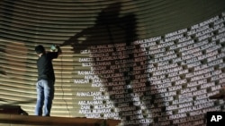 FILE - A worker installs names of the victims of the 2004 Indian Ocean tsunami on the wall of the Tsunami Museum ahead of the 10th anniversary of the killer waves in Banda Aceh, Aceh province, Indonesia, Dec. 4, 2014. The 20th anniversary will be observed on Dec. 26 this year.