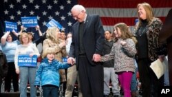 Democratic presidential candidate Sen. Bernie Sanders of Vermont, center, is joined by his wife Jane, right, and grandchildren, Dylan, 4, and Ella, 7, at a town hall at the Orpheum Theater in Sioux City, Iowa, Jan. 19, 2016. (AP Photo/Andrew Harnik)