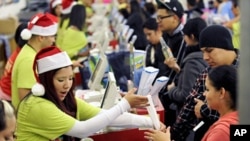 Shoppers pay for their purchases at an Old Navy store as "Black Friday" shoppers get an early start at the Citadel outlet stores on Thanksgiving in Los Angeles, California November 24, 2011