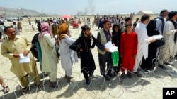 In this Aug. 17, 2021, file photo, hundreds of people gather outside the international airport in Kabul, Afghanistan. (AP Photo/File)