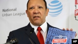National Urban League President and CEO Marc Morial holds up a copy of the 2017 State of Black America report, May 2, 2017, at the National Urban League in Washington.