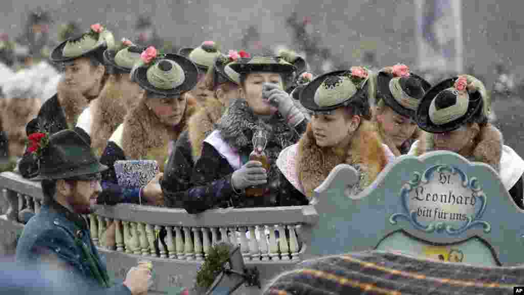 Women wearing the traditional costumes of the region sit in a horse-drawn carriage during the traditional Leonhardi pilgrimage in Bad Toelz, southern Germany.