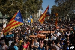 Protesters hold Catalan flags during a rally outside the Catalan parliament in Barcelona, Spain, Oct. 27, 2017.