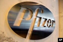 FILE - The Pfizer company logo is photographed at Pfizer Inc. headquarters, in New York, Dec. 4, 2017.