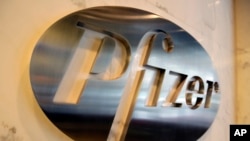 FILE - The Pfizer company logo is photographed at Pfizer Inc. headquarters, in New York, Dec. 4, 2017.