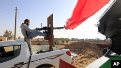 A Libyan rebel fighter aims his heavy machine gun towards forces loyal to Libya's leader Moammar Gadhafi at Misrata's western front line, some 25 kilometers from the city center, May 26, 2011.