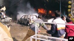 FILE - Vehicles are on fire after a blast in Peshawar, Pakistan, Dec. 5, 2009. 