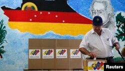 Un elector deposita su voto en Caracas, durante las elecciones municipales de este domingo.