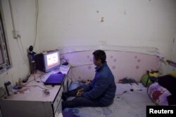Jiang Shuaihui, 25, a worker from Henan province plays video games in a room he is renting in Tongzhou district of Beijing, Feb. 25, 2016.