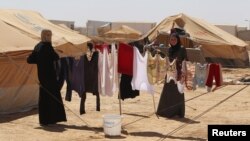 叙利亚人在靠近叙利亚边境的约旦难民营内晾晒衣服