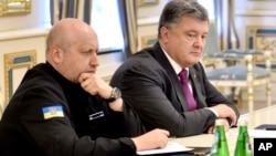 FILE - Ukraine's President Petro Poroshenko, right, and Oleksandr Turchynov, Chairman of Ukraine's National Security and Defense Council, chair a council meeting in Kyiv, Ukraine, Aug. 11, 2016. Both Poroshenko and Turchynov have made cybersecurity a strategic priority.