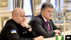 Presiden Ukraina Petro Poroshenko (kanan) dan Kepala Dewan Pertahanan dan Keamanan Ukraina Oleksandr Turchynov berbincang di sesi dewan tersebut di Kiev, Ukraina Kamis (11/8).