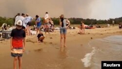 Personas atrapadas junto al mar tras huir de los incendios forestales en Batemans Bay, Australia el 31 de diciembre de 2019.