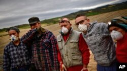 Los trabajadores temporeros Ana, izquierda, posan para el fotógrafo con su esposa Blas López, de 54 años, y Diego de La Torre junto a su hijo Jonatan, de 21 años, y su esposa Maria Rivera, de 42 años, mientras recogía espárragos blancos del campo en Uterga, a unos 15 km (9 millas) de Pamplona, norte de España, el domingo 5 de abril de 2020.