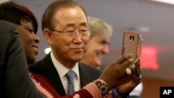 United Nations Secretary-General Ban Ki-moon poses for a selfie with one of his staff members on his last day at the U.N. headquarters, Dec. 30, 2016.