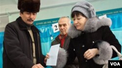 Warga Kazakhstan memasukkan kertas suaranya di pusat kota Almaty (15/1).