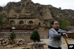 2012年10月18日，一個農民站在習近平青年時期在中國陝西省梁家河住過的窯洞附近。