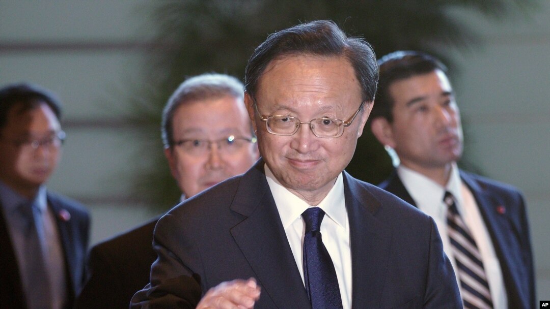FILE - Chinese State Councilor Yang Jiechi greets the media as he walks to meet Japanese Prime Minister Shinzo Abe at Abe's official residence in Tokyo in May 2019.