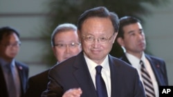 FILE - Chinese State Councilor Yang Jiechi greets the media as he walks to meet Japanese Prime Minister Shinzo Abe at Abe's official residence in Tokyo in May 2019.