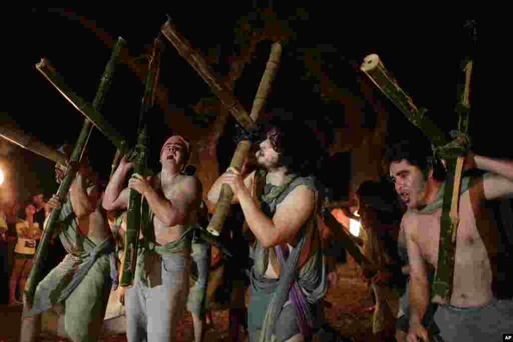 Actors carry crosses during a &quot;Via Crucis,&quot; during a performance at the Carlos Antonio Lopez park in Asuncion, Paraguay, March 31, 2015.