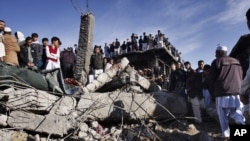 Local residents stand over the rubble of a damaged market caused by Saturday's bombing in Quetta, Pakistan on February 17, 2013. 