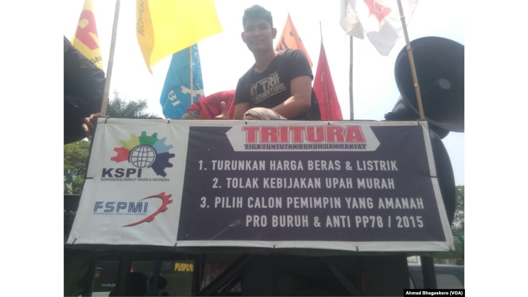 Seorang peserta unjuk rasa di depan Kedutaan Besar Amerika Serikat di Jakarta, dengan membawa spanduk yang menyuarakan tuntutan mereka terhadap pemerintah AS, 8 Oktober 2018. (Foto: VOA/ Ahmad Bhagaskoro)