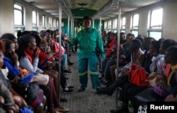 FILE - A train conductor walks inside a carriage as passengers ride inside a Nairobi Commuter Rail Service train from the Mutindwa station in Nairobi, Kenya, Nov. 12, 2018.