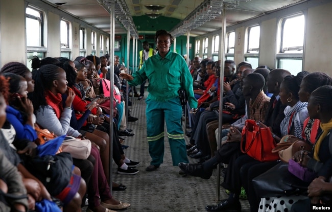 FILE - A train conductor walks inside a carriage as passengers ride inside a Nairobi Commuter Rail Service train from the Mutindwa station in Nairobi, Kenya, Nov. 12, 2018.