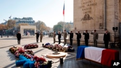 Prezidan Franse a Emmanuel Macron kanpe devan Tonbo Solda Enkonu a anba Arc de Triomphe la nan Paris, 11 Nov. 2021.