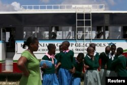 FILE - Students arrive at the start of a social event advocating against harmful practices such as female genital mutilation at the Imbirikani Girls High School in Imbirikani, Kenya, April 21, 2016.