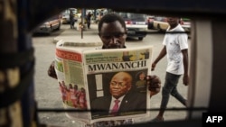 A man reads a newspaper with a headline announcing the death of Tanzania's President John Magufuli in Dar es Salaam, on March 18, 2021.