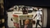 A man reads a newspaper with a headline announcing the death of Tanzania's President John Magufuli in Dar es Salaam, on March 18, 2021.