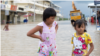 Girls stand in a flooded area of Prek Chrey village, Spean Tmor commune, Dangkoa district, Phnom Penh, Cambodia, on Oct. 15, 2020. (Malis Tum/VOA Khmer)