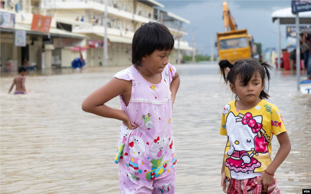 Girls stand in a flooded area of Prek Chrey village, Spean Tmor commune, Dangkoa district, Phnom Penh, Cambodia, on Oct. 15, 2020. (Malis Tum/VOA Khmer)