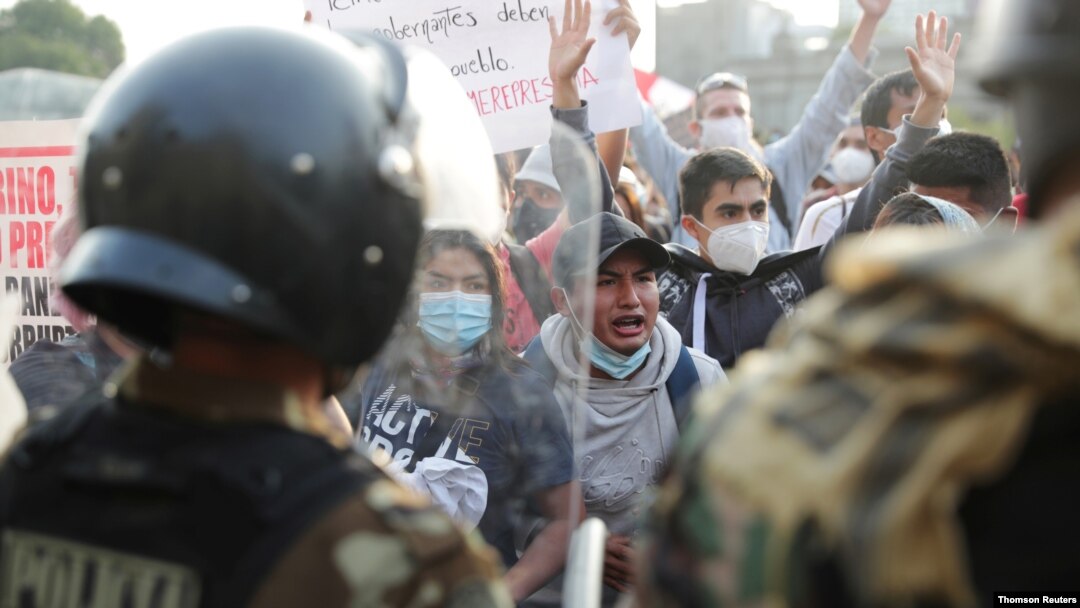 Agentes de policía bloquean a manifestantes durante las protestas tras el juicio político al presidente Martín Vizcarra, en Lima, el 11 de noviembre de 2020.