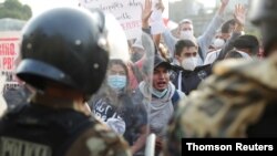 Agentes de policía bloquean a manifestantes durante las protestas tras el juicio político al presidente Martín Vizcarra, en Lima, el 11 de noviembre de 2020.