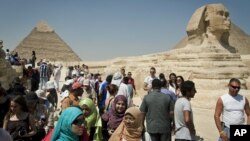 In this September 27, 2012 photo, foreign tourists visit the historical site of the Giza Pyramids, near Cairo, Egypt.