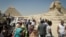 In this September 27, 2012 photo, foreign tourists visit the historical site of the Giza Pyramids, near Cairo, Egypt.