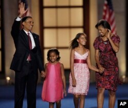 FILE - Calon presiden dari Partai Demokrat, Senator Barack Obama, bersama istrinya, Michelle, dan kedua putrinya Malia (10 tahun), dan Sasha (7 tahun), seusai pidato penerimaannya di Konvensi Nasional Partai Demokrat di Denver, 28 Agustus 2008. (Ron Edmonds/AP)