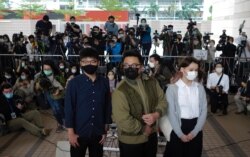 Hong Kong activists, from left, Joshua Wong, Ivan Lam and Agnes Chow arrive at a court in Hong Kong, Monday, Nov. 23, 2020. The trio appears at court for their trial as they face charges related to the besieging of a police station.