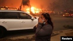 Žena na putu u mestu Altadena, 8. januar 2025. (REUTERS/David Swanson)