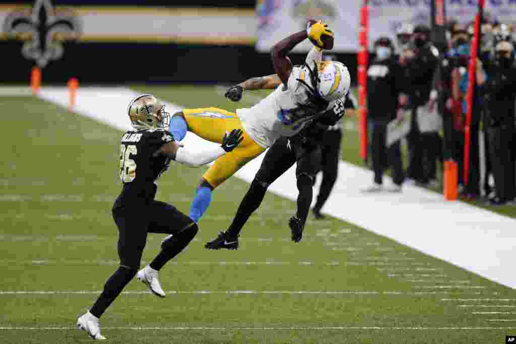 Los Angeles Chargers wide receiver Mike Williams (81) pulls in a pass between New Orleans Saints cornerback P.J. Williams (26) and cornerback Marshon Lattimore (23) in the second half of an NFL football game in New Orleans, Loisiana, Oct. 12, 2020.