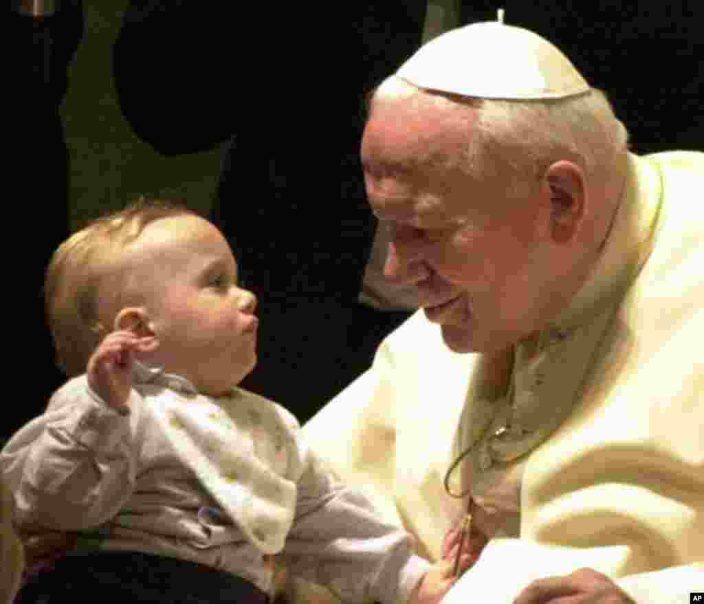 Pope John Paul II and an unidentified baby smile at each other in 2001 (AP Photo/Plinio Lepri)