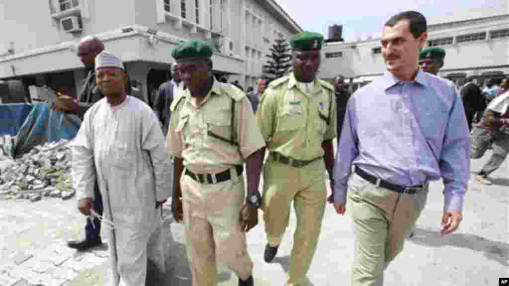 Usman Abbas, left and  Nigeria, Azim Aghajani, right,  an Iranian citizen, are led away by prison officials, at the Federal High Court, after their sentencing, in Lagos, Monday, May 13, 2013.