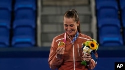 Belinda Bencic of Switzerland looks at her gold medal in the women's singles of the tennis competition at the 2020 Summer Olympics, July 31, 2021, in Tokyo, Japan. 