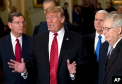 President Donald Trump, accompanied by Vice President Mike Pence, second right, and Senate Majority Leader Mitch McConnell, right, talks to the media after a Senate Republican policy lunch on Capitol Hill, in Washington, Jan. 9, 2019.