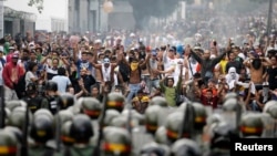 Supporters of opposition leader Henrique Capriles face off against riot police as they demonstrated for a recount of the votes in Sunday's election, in Caracas, Apr. 15, 2013. 