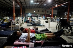 FILE - Disabled migrant Jose Serrano, from Honduras, checks the internet on his mobile phone in a provisional shelter during his journey toward the United States, in Piedras Negras, Mexico, Feb. 4, 2019.