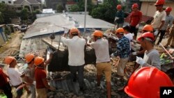 Socorristas intentan retirar escombros el domingo 23 de junio de 2019 en busca de víctimas tras el derrumbe el día anterior de un edificio en construcción en Sihanoukville, Camboya. (AP Foto/Heng Sinith)